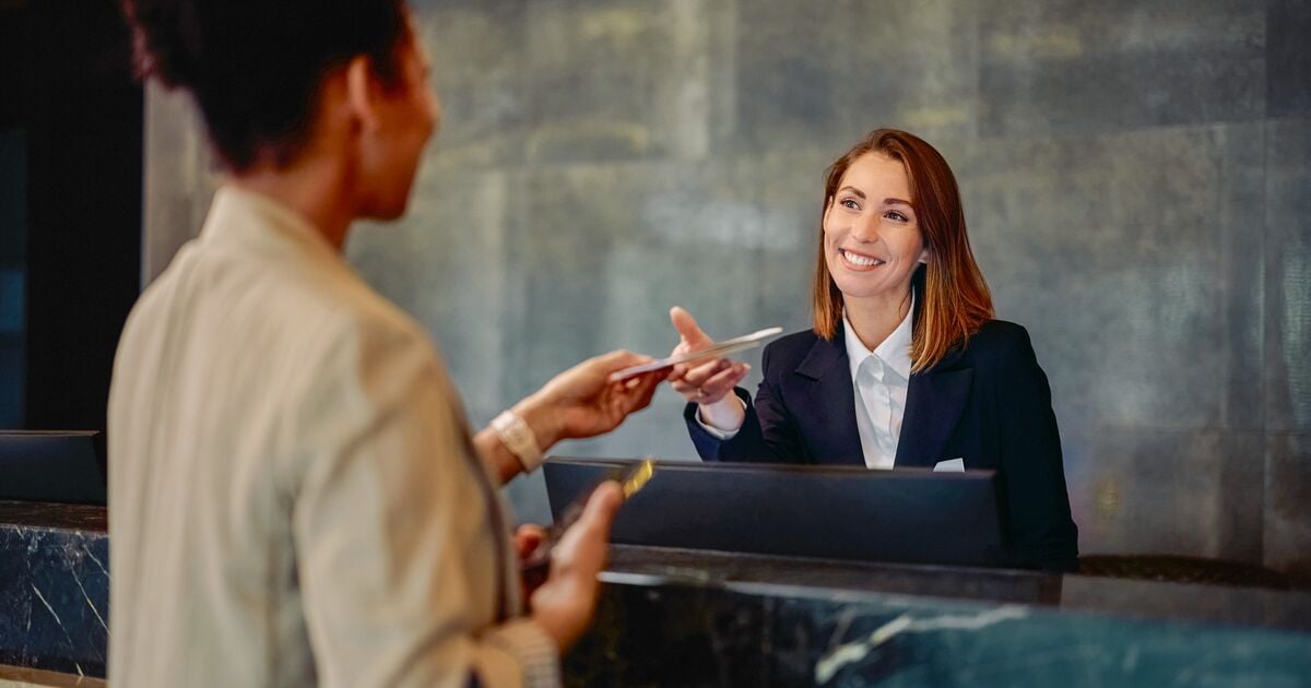 Medium-Happy receptionist talking to guest.